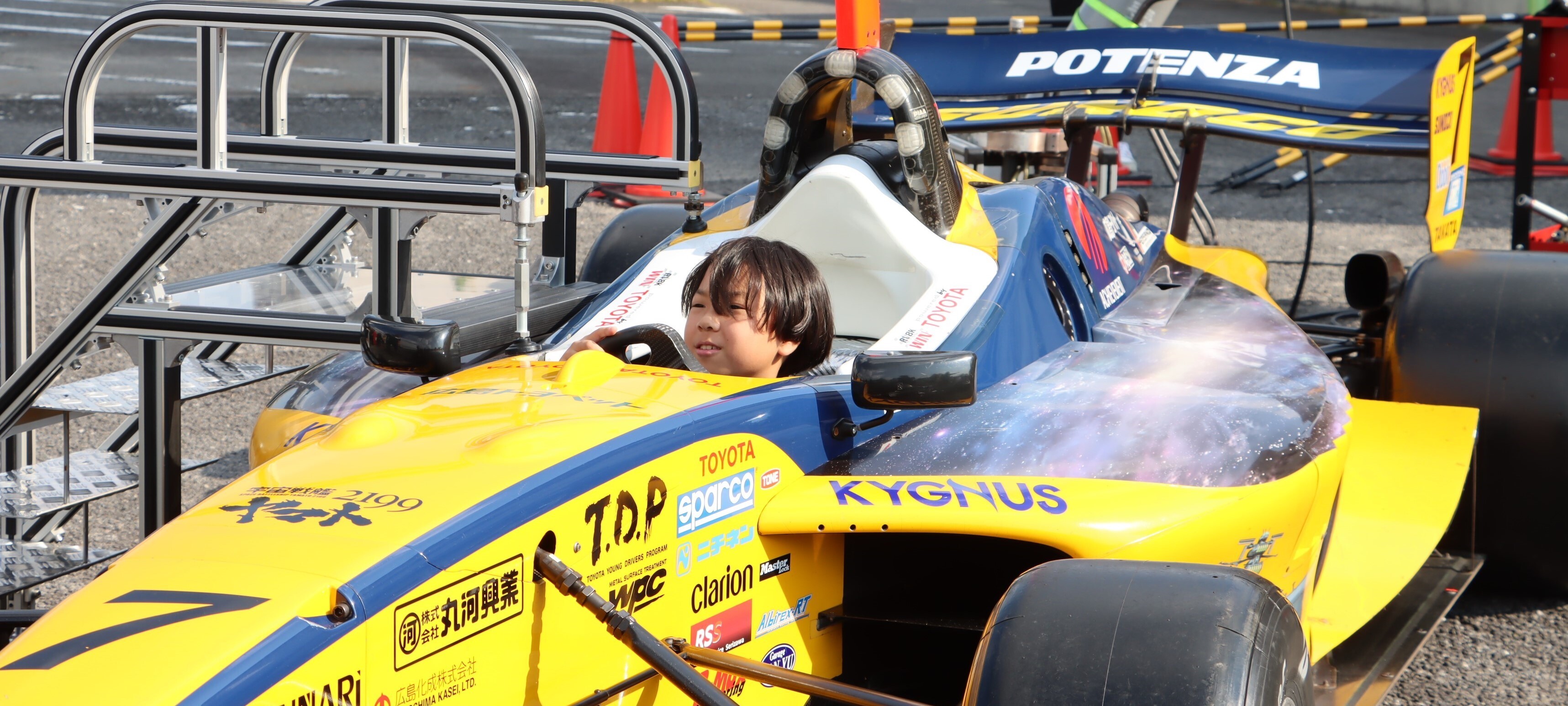 プロドライバーによる出前授業。スーパーフォーミュラのマシンに乗り込む児童