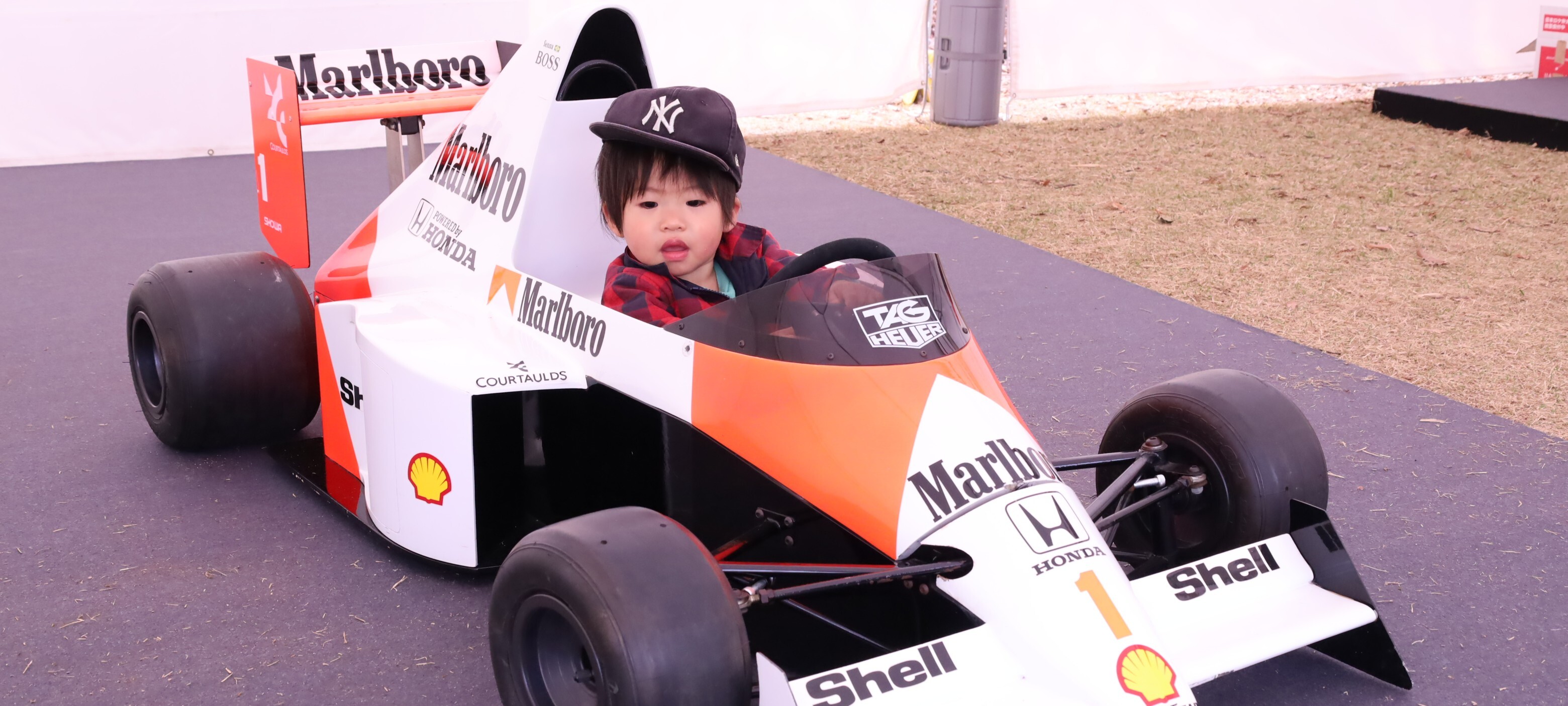 SUZUKA GRAND SPRING MARKETでF1マシンに乗り込むこどもの写真