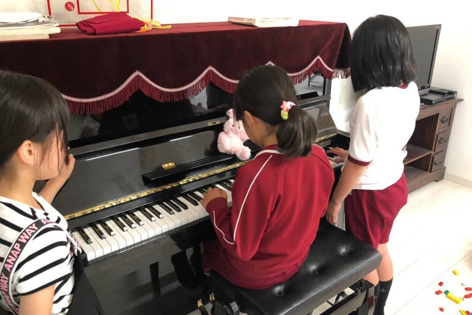 写真：ピアノを弾く子どもたち