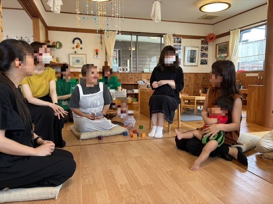 写真：先輩ママから激励される様子