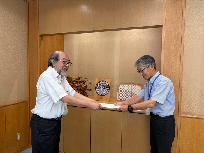 写真：会長（左）から上下水道事業管理者（右）へ答申書の手交
