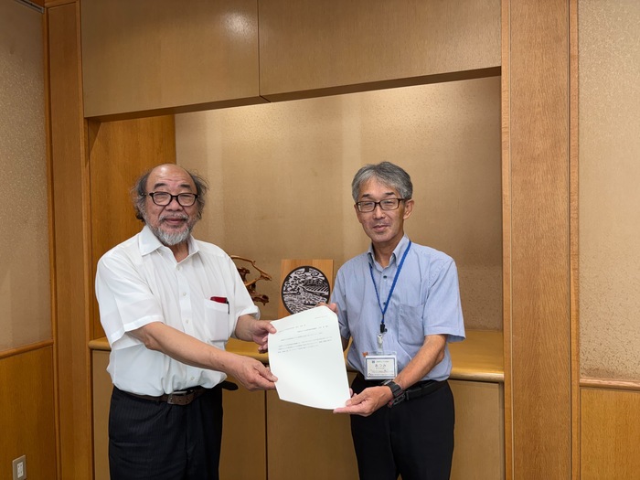 写真：会長（左）から上下水道事業管理者（右）へ答申書の手交